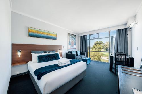 悉尼The Select Inn Ryde的一间酒店客房,设有一张大床和一个大窗户