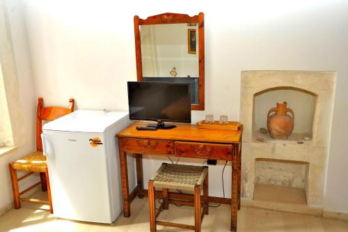 罗希姆诺拜占庭酒店的客房设有一张书桌、一台冰箱和一面镜子