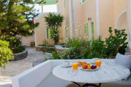 卡马利乔安娜别墅酒店的一张桌子,上面放有一盘水果和两杯橙汁