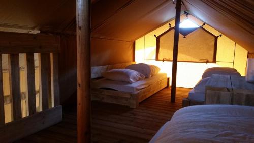 卢特伦Safari lodge tent op prachtige plek的一间帐篷内带两张床的卧室