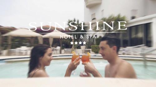 里卡迪Sunshine Club Hotel Centro Benessere的男人和女人在游泳池里喝饮料