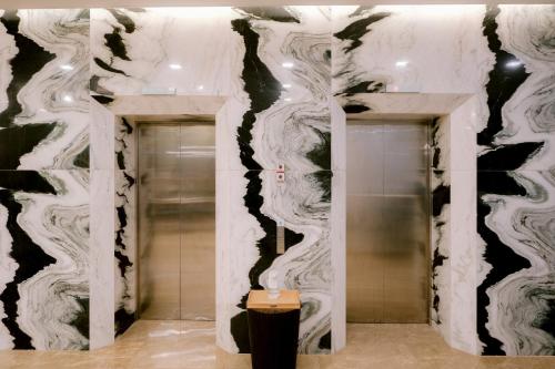 宿务Goldberry Suites and Hotel Cebu的浴室拥有黑白色墙壁,设有电梯。