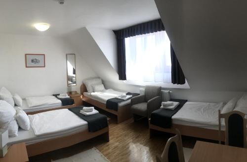 赛伦奇Huszárvár Hotel Kastélyszálló的小房间设有三张床和窗户