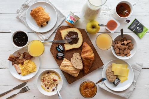 圣茹昂代盖雷特B&B HOTEL Saint Malo Sud的餐桌上摆放着早餐食品和饮料