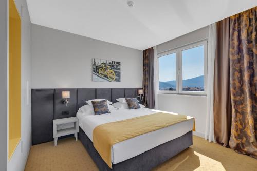 默主歌耶马可尼酒店的一间卧室设有一张大床和一个窗户。