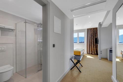 默主歌耶马可尼酒店的一间带卫生间和玻璃淋浴间的浴室