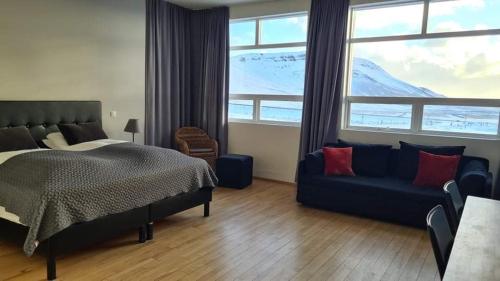 维克火山酒店 的一间卧室配有一张床、一张沙发和一个大窗户
