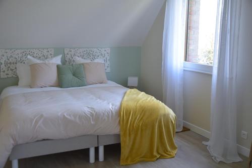 VerlinghemLes chambres du Vert Galant "Coucher de soleil"的一间卧室配有一张黄色毯子床