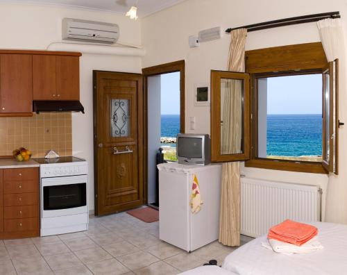 帕诺尔莫斯雷斯蒙克里斯汀公寓酒店的厨房配有冰箱和海景窗户。