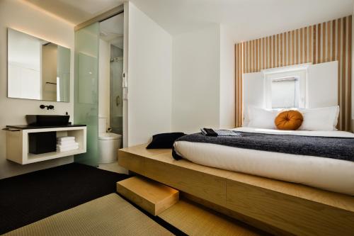 维塞乌Viseu Ryokan - Hospedaria Japonesa & SPA的一间带大床的卧室和一间浴室