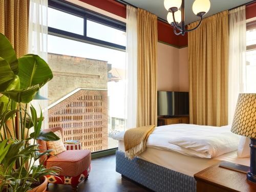 哥本哈根25hours Hotel Indre By的一间卧室设有一张床和一个大窗户
