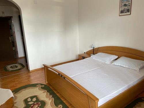 Mînăstirea NeamţCasa de Pelerinaj Ierusalim Hozeva的一间卧室配有一张带白色床单的木床