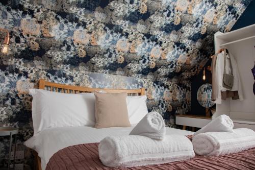 布罗德福德Croft4的一间卧室配有一张带花卉壁纸的床