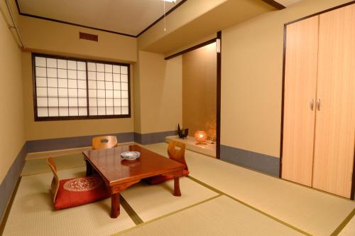 京都丽达酒店的客厅配有木桌和椅子
