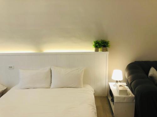 南湾海沐輕旅 Sea Mu Kenting的卧室配有白色的床和沙发