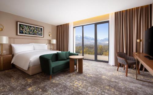 阿拉木图Swissôtel Wellness Resort Alatau Almaty的酒店客房设有一张床和一个大窗户