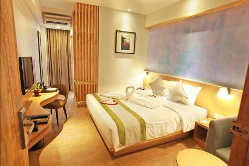 金巴兰Liberta Hotel Jimbaran的配有一张床和一张书桌的酒店客房