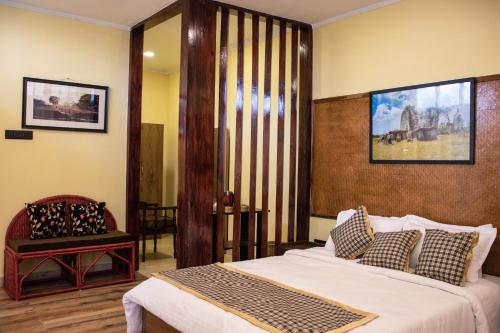 西隆The Arcadia Resort - Umroi的一间卧室配有一张大床和一把椅子