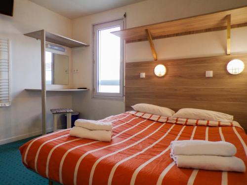 若奈克朗普瓦捷未来世界法斯特酒店的一间卧室配有一张大床和毛巾