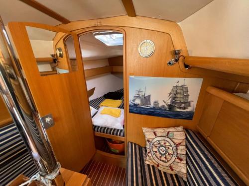 洛迦诺Barca a vela sul lago Maggiore的小房间,配有一张床和一张船的照片