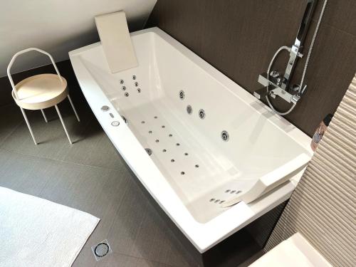 索非亚Unique Luxurious Jacuzzi PENTHOUSE DUPLEX in City Center! 2 BATHS! FREE PARKING!的浴室设有白色浴缸及椅子