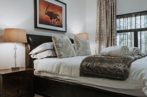 开普敦Bloemendal Wine Estate Accommodation的一间卧室配有一张带白色床单的床和一扇窗户。