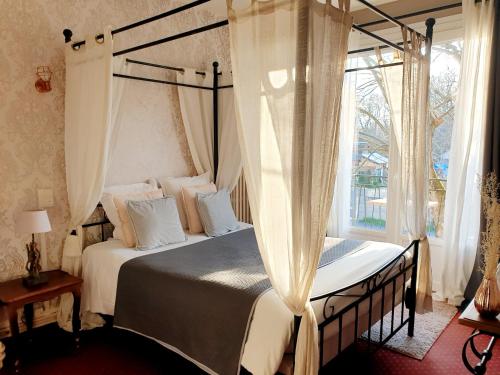 拉法特盛赛尔圣塞尔酒店的一间卧室设有天蓬床和窗户。