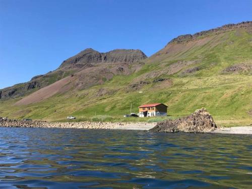 NorðurfjörðurGistiheimilið Bergistangi 1的水体岸边的房子