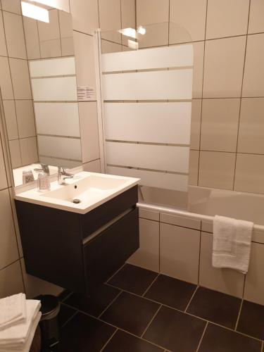 拉法特盛赛尔圣塞尔酒店的一间带水槽、浴缸和镜子的浴室