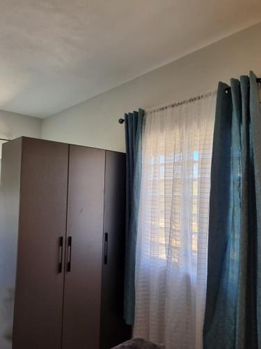 瓦利Bel Ti Plas的一间卧室设有窗户,配有窗帘和橱柜