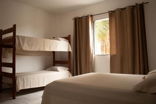 大普拉亚Solar Vila Mirim的一间卧室设有两张双层床和一扇窗户。