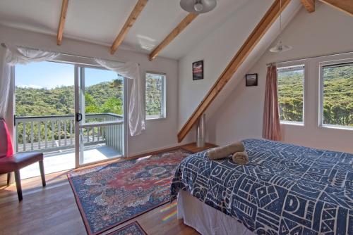 TryphenaFrosty's Retreat - Great Barrier Island Home的一间卧室设有一张床和一个阳台