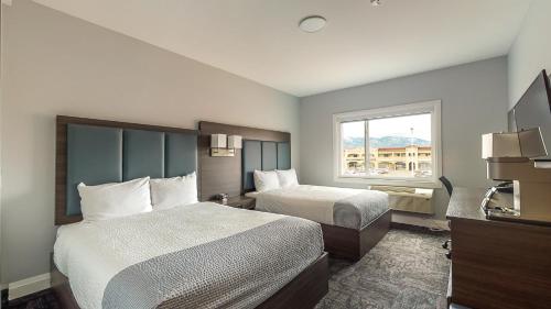 奥索尤斯Park Inn by Radisson Osoyoos的酒店客房设有两张床和窗户。