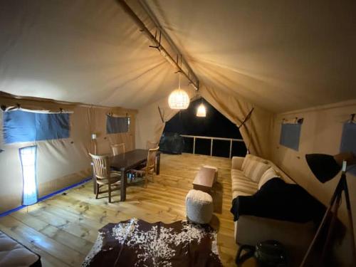 WaipapaLynx Lodge的带一张桌子和一张沙发的帐篷客房