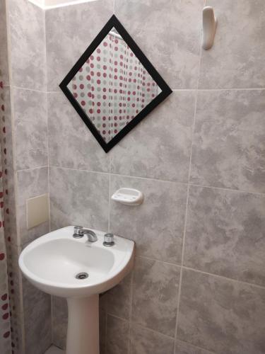 雷西斯膝西亚Departamento Temporario的浴室设有水槽和墙上的镜子