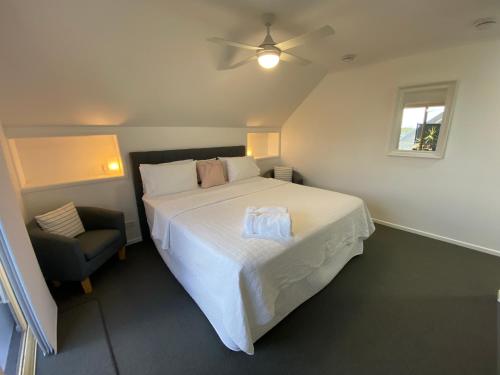 彩虹海滩Rainbow Beach Dream的卧室配有一张白色大床和一把椅子
