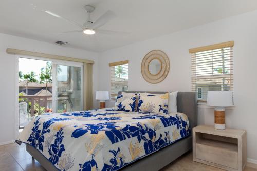 瓦克拉Waikoloa Colony Villas #2105的一间卧室配有一张带蓝色和白色棉被的床