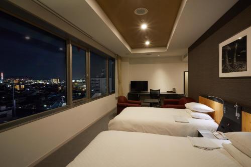 京都京都犀牛酒店的酒店客房设有两张床和大窗户。