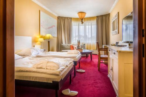 布拉格优雅酒店的酒店客房配有两张床和一张书桌