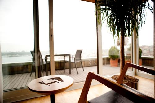 伊斯坦布尔伊斯坦布尔威特套房酒店的带阳台的客房内的桌椅