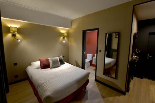 瑟堡Hôtel Le Tiburon的酒店客房,配有床和镜子