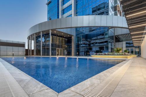 阿可贺巴Somerset Downtown Al Khobar的一座大型建筑,前面设有一个游泳池