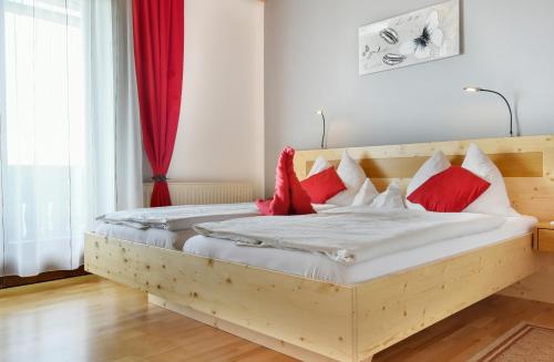 Schöder盖斯特豪斯比斯乔夫酒店的一间卧室配有一张带红色枕头的木床。