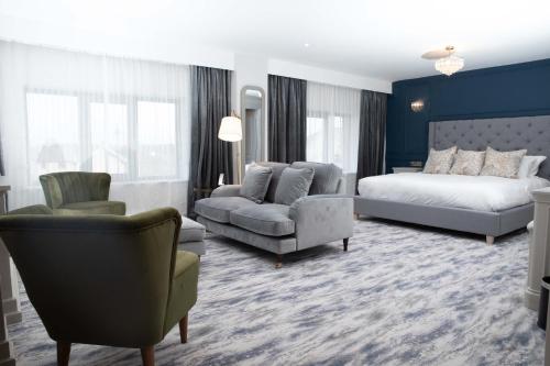 GeesalaErris Coast Hotel的一间卧室配有一张床、一张沙发和一把椅子