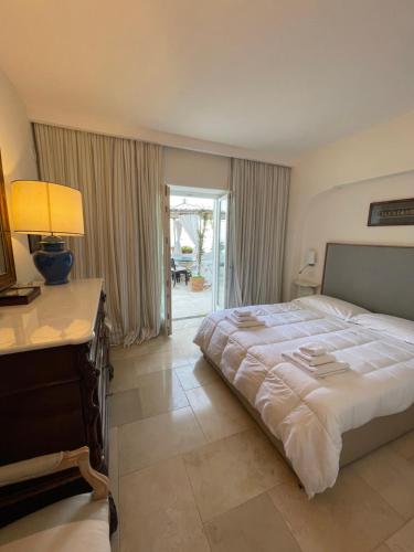 卡普里Villa le stelle capri的一间卧室配有一张床和一张带台灯的书桌