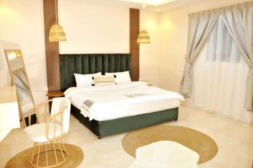 艾卜哈Msakn Aldar的一间卧室配有一张大床和一把椅子