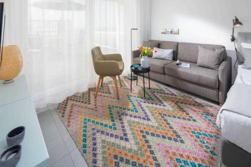 诺德奈WestStrandBlick的客厅配有沙发和色彩缤纷的地毯