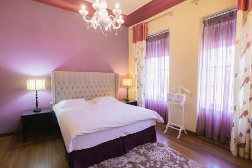 纳夫普利翁Kastello Hotel的卧室配有白色的床和吊灯。