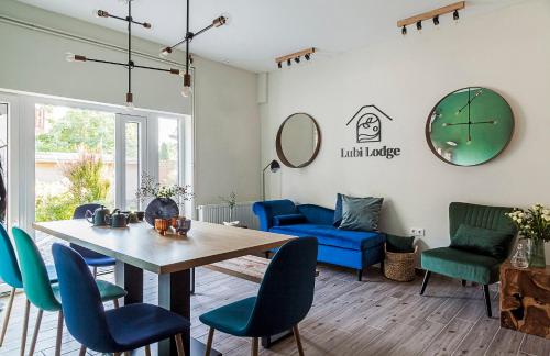 巴拉顿博格拉尔Lubi Lodge的客厅配有桌子和蓝色椅子