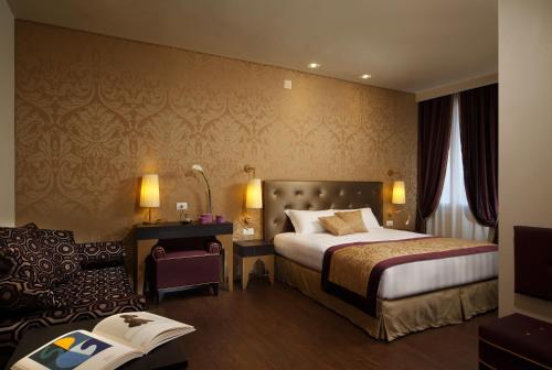 威尼斯阿卡迪亚精品酒店的配有一张床和一把椅子的酒店客房
